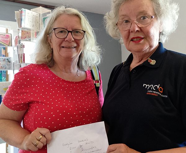 Alison yn cyflwyno £250 i Georgina, gwirfoddolwr Grwp Cefnogi MND 