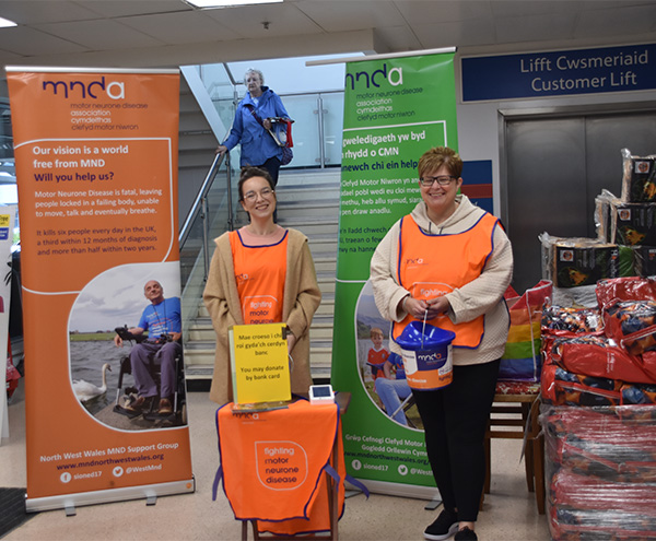 Dau person yn cynnal casgliad yn Tesco Extra, Caergybi