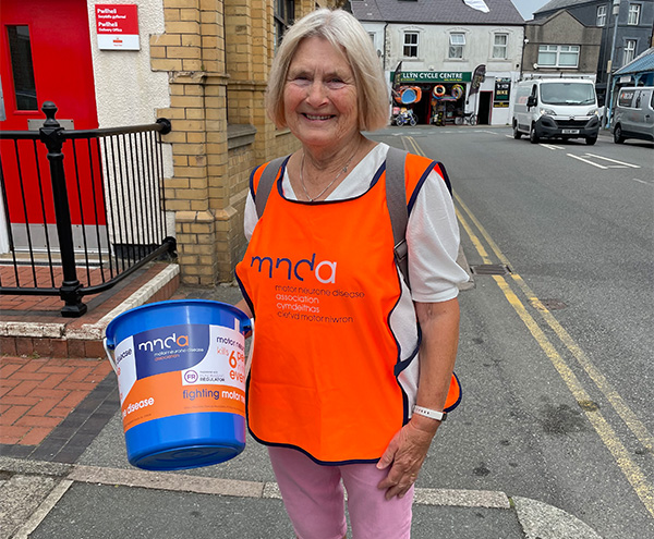 Person y gafael mewn bwced Chlefyd Motor Niwron yn Pwllheli